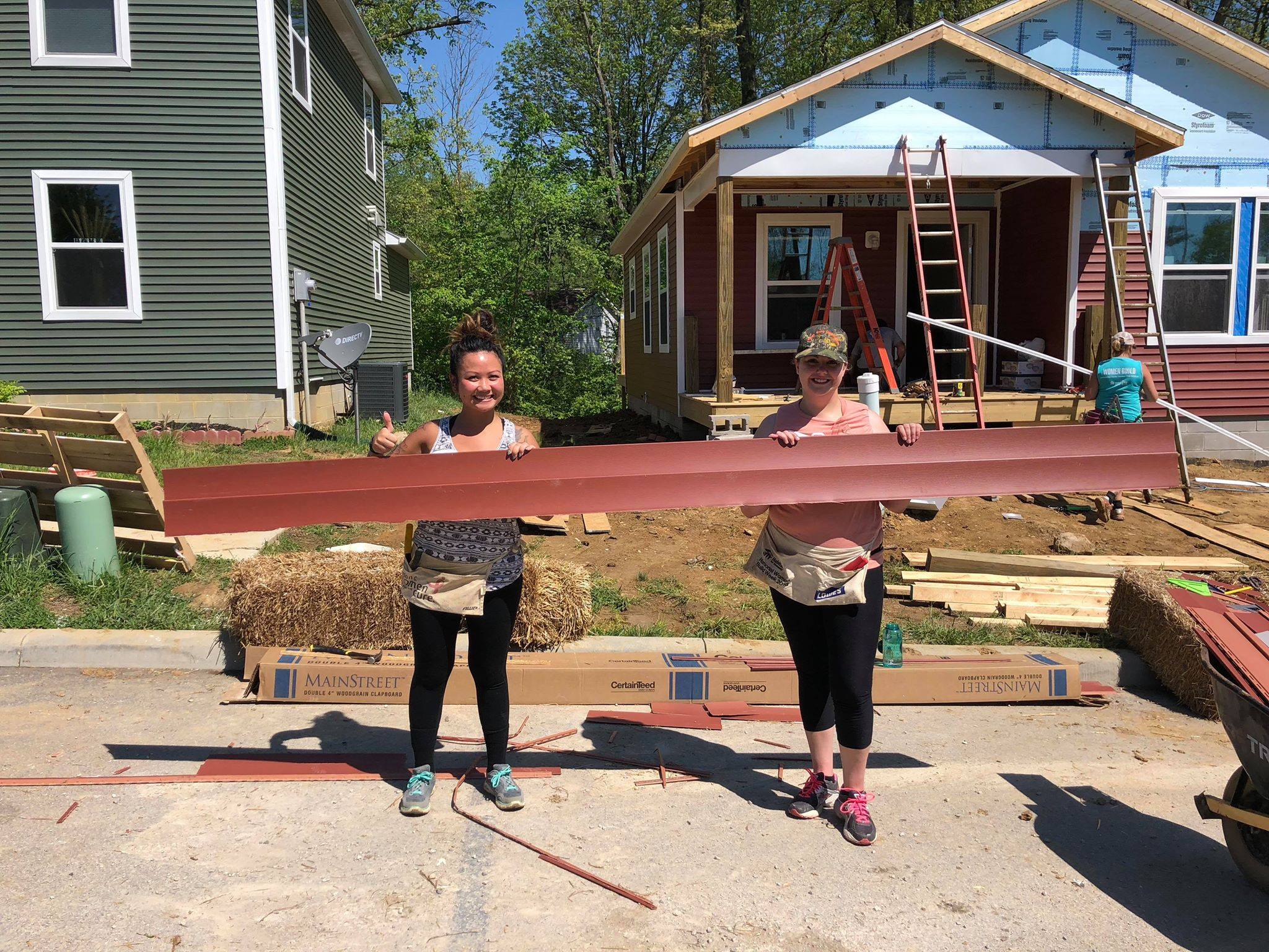 IUCU employees trim vinyl siding for the Women's Build 2018