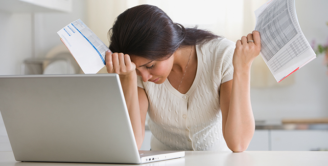 Photo of a worried woman paying bills.