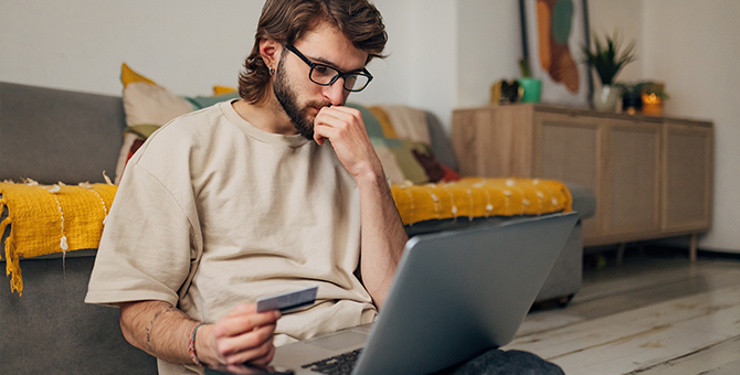 Photo of a concerned man working on laptop computer.