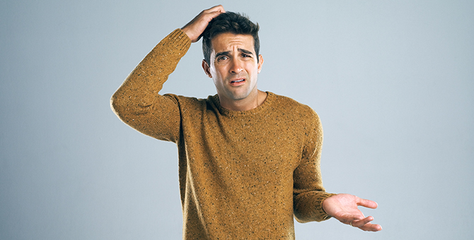 Photo of a man scratching his head.
