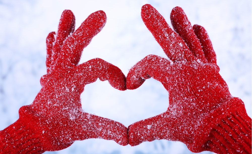 Photo of hands holding snow shaped like a heart